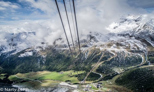 Maso Corto widziane z górnej stacji gondoli (foto: Piotr Burda Jesienny widok na alpejską dolinę, w tle ośnieżone już szczyty i czekjące na śnieg trasy narciarki, na poierwszymplanie liny kollei gondolowej
