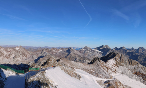 Obraz z kamery internetowej z Café 3440 na lodowiec Pitztal (25 09 2026 g. 8:30/ źródło https://www.pitztaler-gletscher.at/en/webcam.html#webcam Szczyty górskie na tle niebieskiego nieba, w górach przygotowane trasy narciarskie na lodowcu