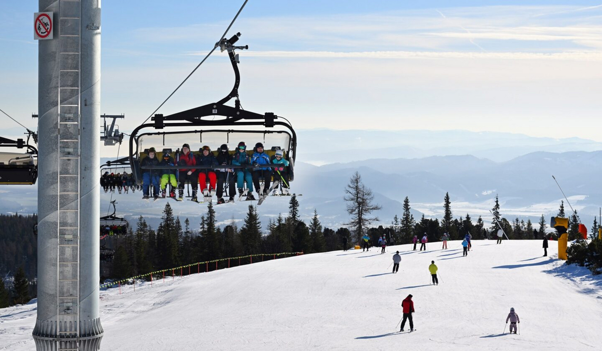 Kolej linowa Szczyrbskie Jezioro (Štrbské Pleso) podczas otwarcia sezonu narciarskiego 2025 — Tatry Wysokie Ośmioosobowy wyciąg krzesełkowy załadowany narciarzami nad stokiem w Szczyrbskim Jeziorze (Štrbské Pleso). W tle słoneczna panorama Tatr Wysokich z narciarzy zjeżdżającymi po białym stoku
