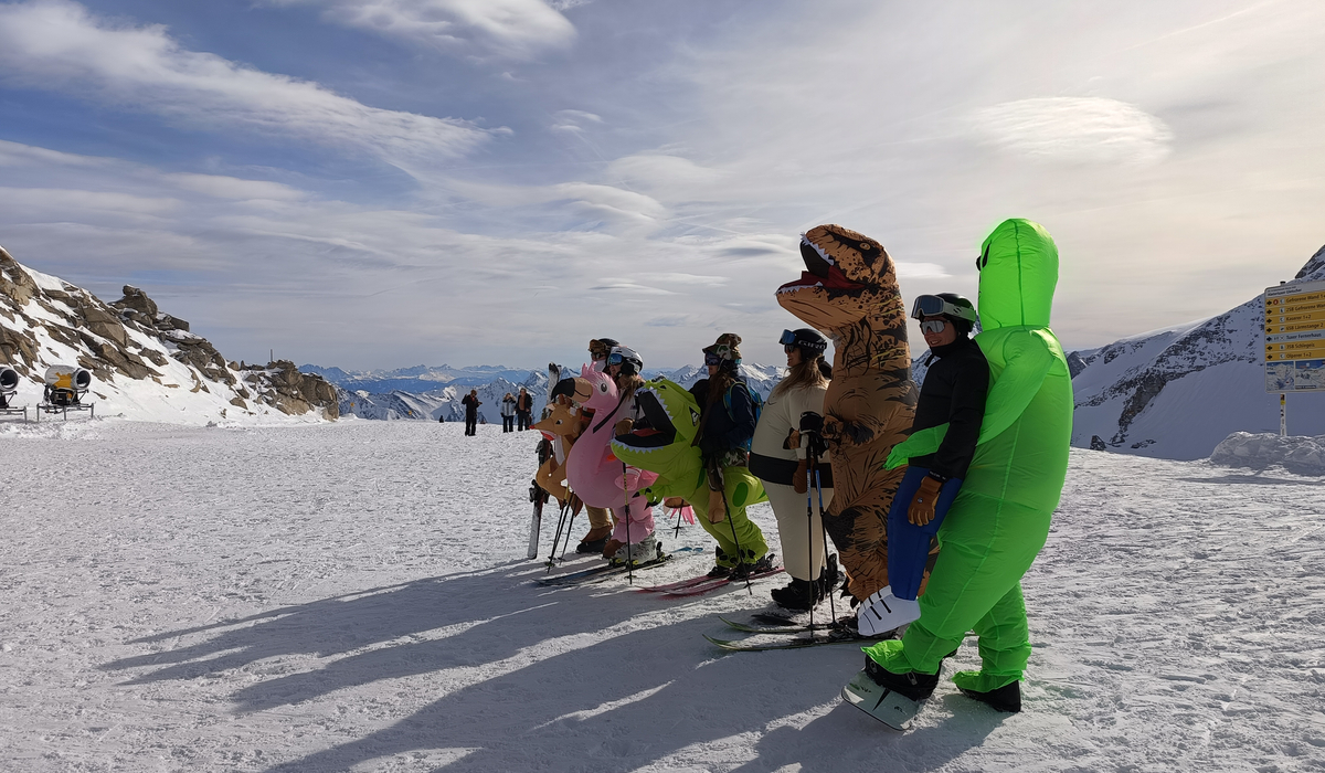 Narciarze przebrani za różne zwierżeta, w tym za dinozaury na ośnieżonym stoku w Zillertal
