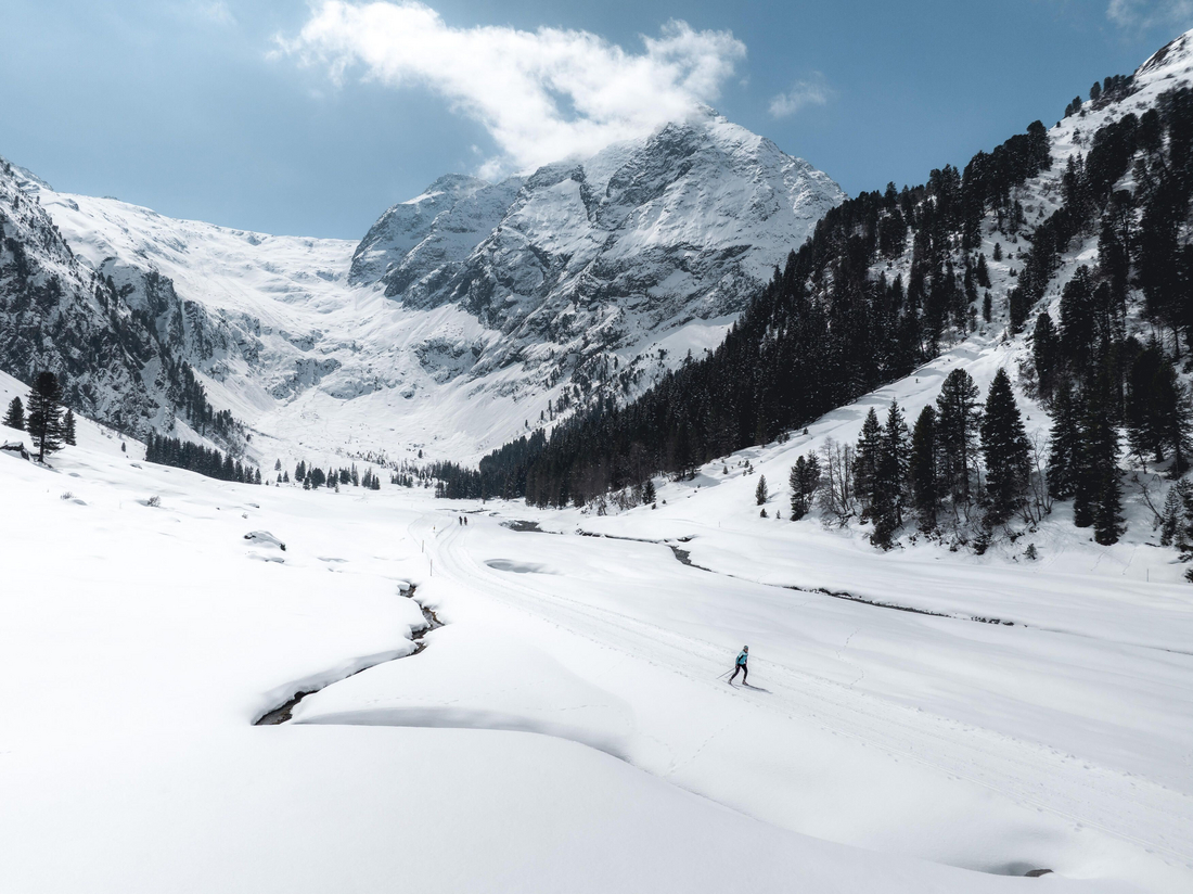 © Innsbruck Tourismus Andreas Vigl Narciarze na nartach begowych w ośnieżonej górskiej dolinie