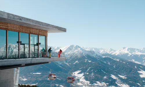 © Innsbruck Tourismus Stefan Ringler Z lewej strzony przeszkolny nowoczesny budynek na tle gór