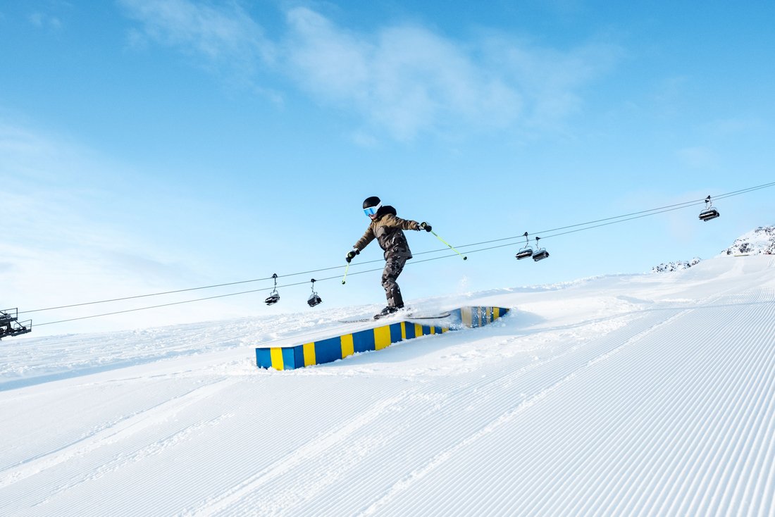 Snowboarder na railu w snowparku