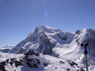 Tam wspinają się ludzie z nartami.