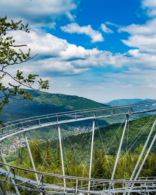 Salamandra Alpine Coaster Szczyrk – budowa kolejki grawitacyjnej na Hali Skrzyczeńskiej Konstrukcja toru Salamandra Alpine Coaster na tle panoramy Szczyrku i beskidzkich lasów
